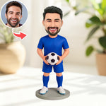 Figura cabezona personalizada de portero sosteniendo un balón de fútbol.
