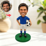 Figura cabezona personalizada de un jugador de fútbol sosteniendo un balón.