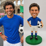 Figura cabezona personalizada de un jugador de fútbol sosteniendo un balón.