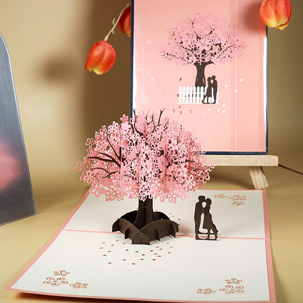 Tarjeta de felicitación emergente 3D de pareja romántica bajo el cerezo