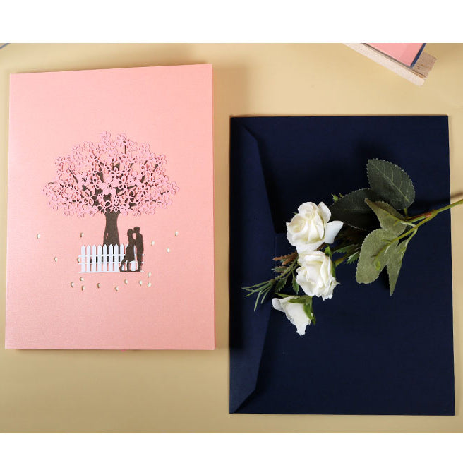 Tarjeta de felicitación emergente 3D de pareja romántica bajo el cerezo