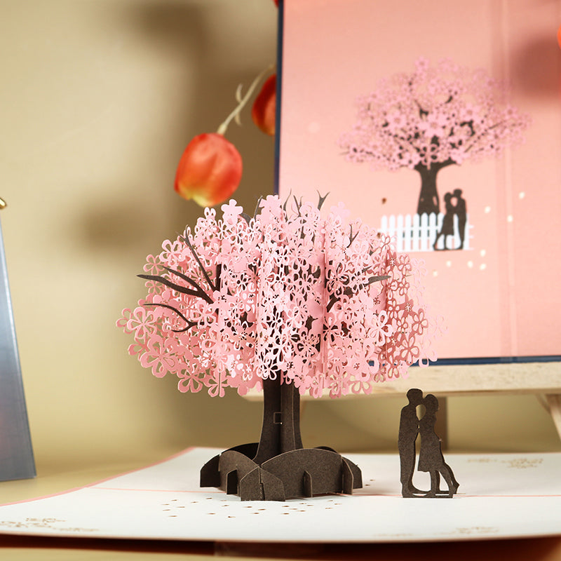 Tarjeta de felicitación emergente 3D de pareja romántica bajo el cerezo